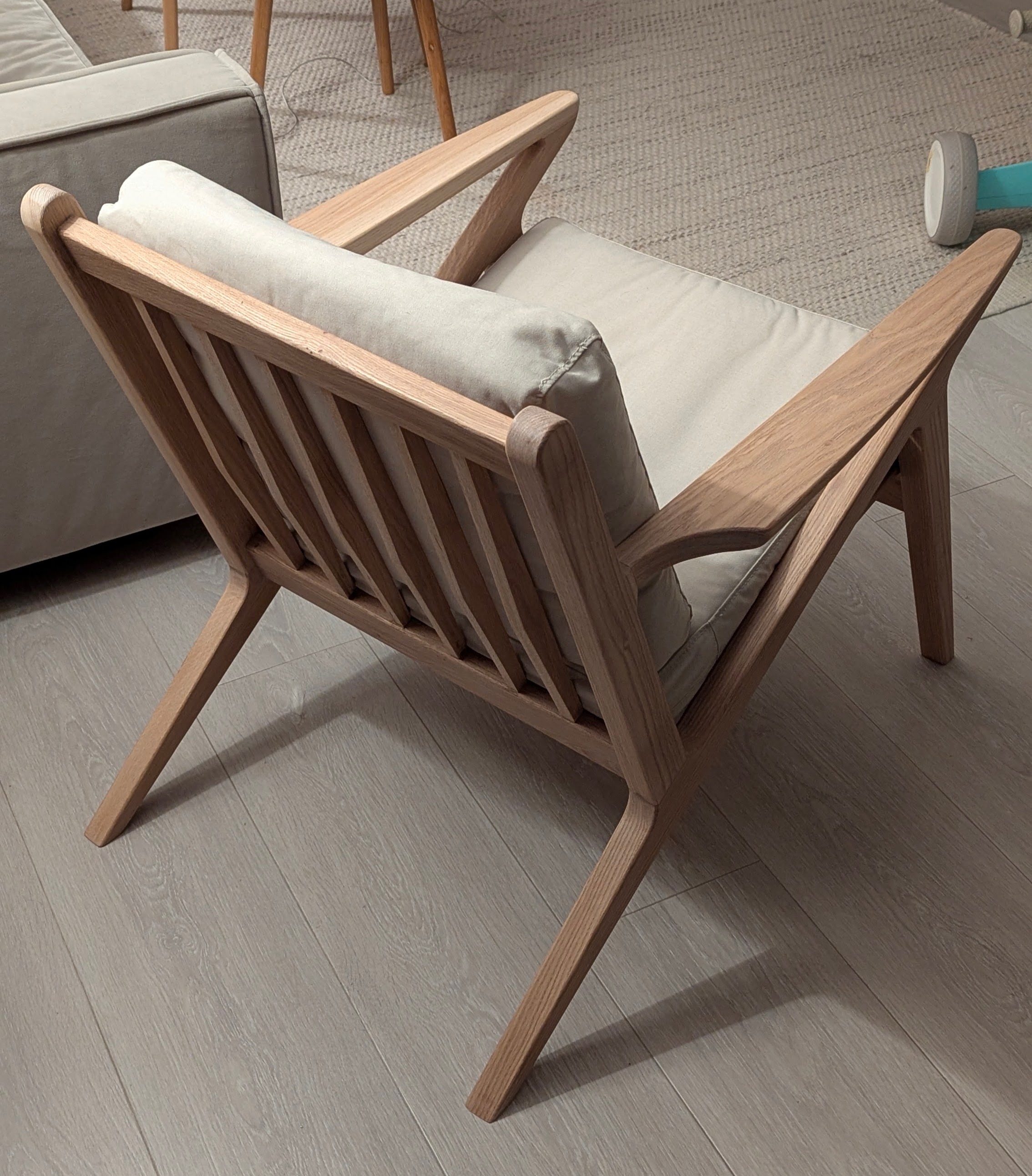 Solid oak lounge chair with slatted back and linen cushions